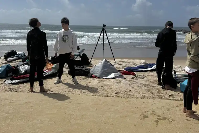 Grupo de treino na praia com o tripé de filmagem montado